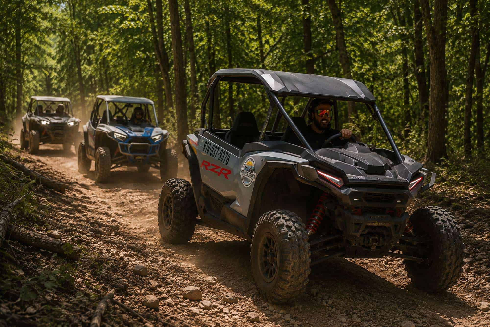 Two Polaris UTVs following a local guide through wooded trails